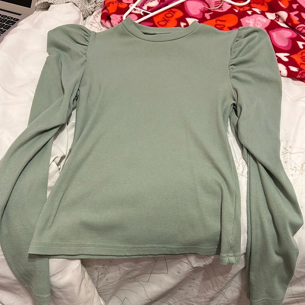 Green blouse with ruffles on shoulders.